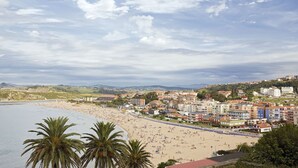 Un paisaje urbano costero con playa, edificios y palmeras.