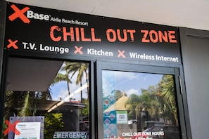 A sign for a Chill Out Zone at Airlie Beach Resort, indicating amenities like a TV Lounge, Kitchen, and Wireless Internet. - Base Airlie Beach Resort - Hostel (Airlie Beach)
