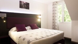 A hotel room with a bed, a headboard, a nightstand, a window with curtains, and a wall-mounted picture. - The Originals City, City Hôtel, Beauvais (Beauvais)