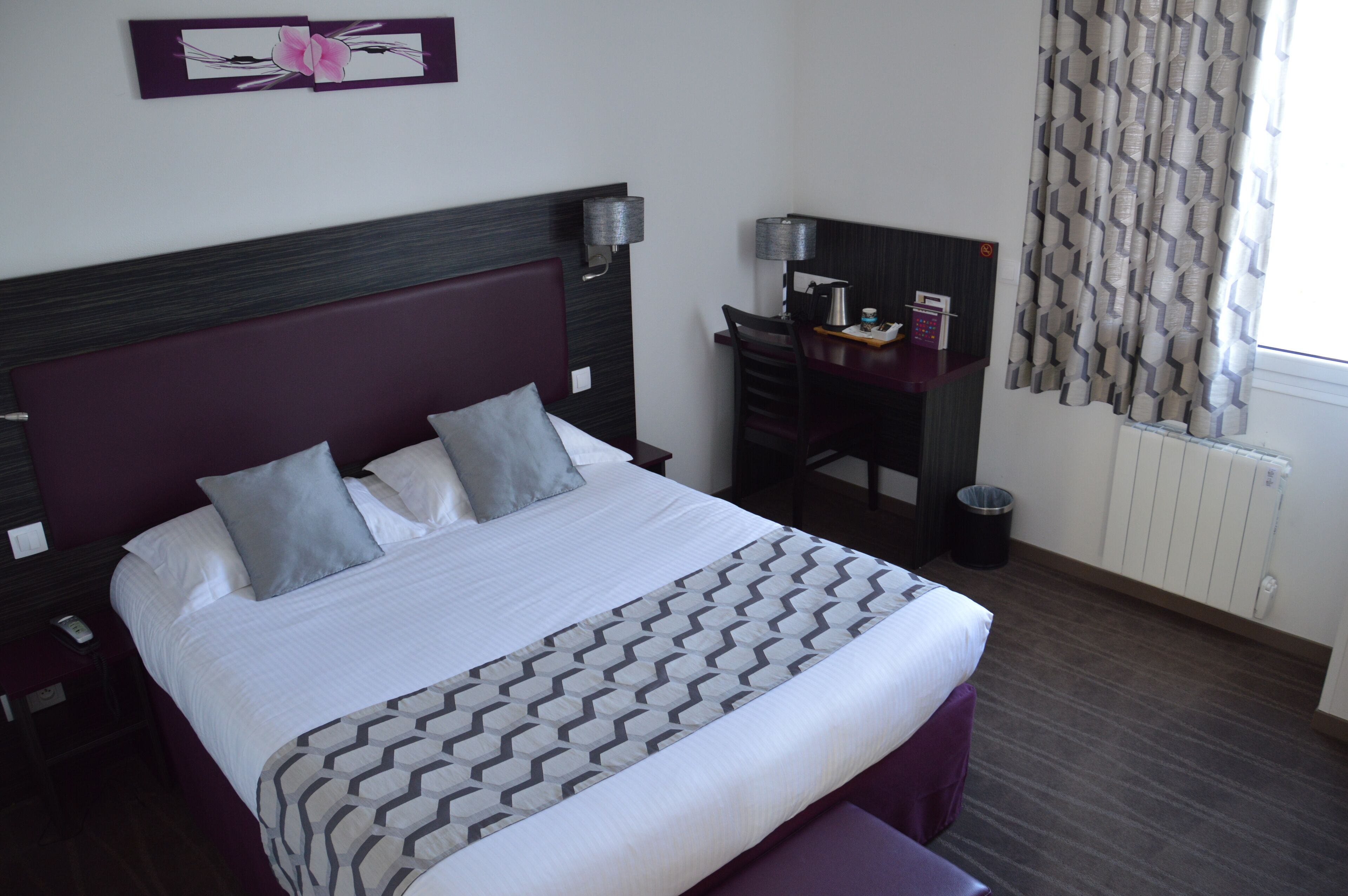 Ein Hotelzimmer mit einem großen Bett, einem Schreibtisch und einem Stuhl.