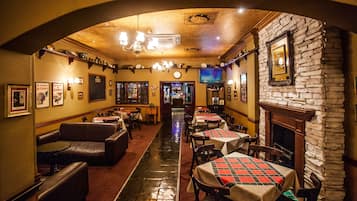 Un restaurante con cabinas, mesas y chimenea.