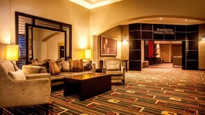 A hotel lobby with a sofa, armchairs, a coffee table, a mirror, and a sign for the fitness center. - Garden Court O.R. Tambo International Airport (Kempton Park)