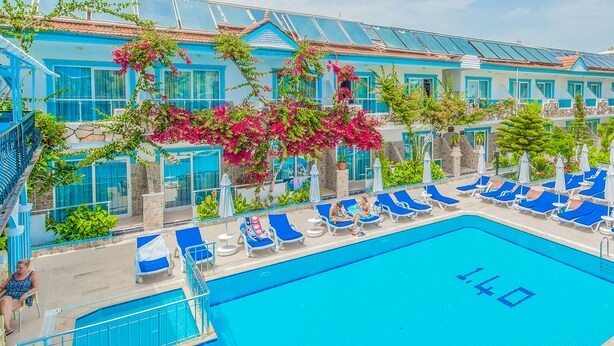 A pool area with blue lounge chairs and a clear blue pool. - Side Sunberk Hotel (Manavgat)