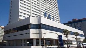 Een hoog, modern hotel met een opvallend bord waarop 'Garden Court' staat.