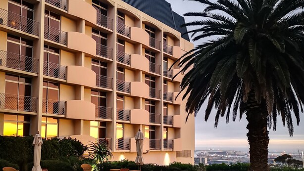 Un hôtel doté d’une piscine, d’un espace extérieur aménagé et offrant une vue sur le paysage urbain.