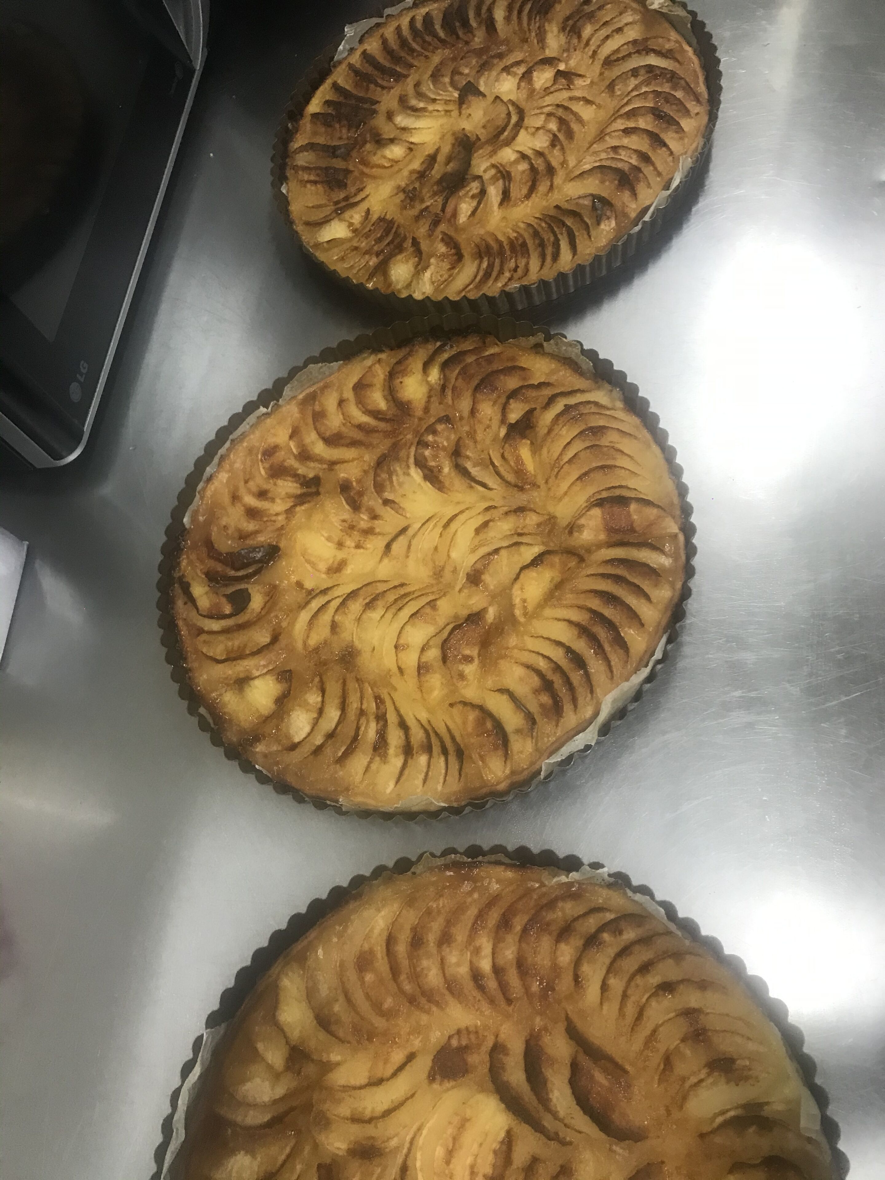 Drei Kuchen mit spiralförmigem Muster auf einer Edelstahl-Arbeitsfläche.