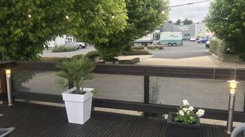 A wooden deck with potted plants and outdoor seating.