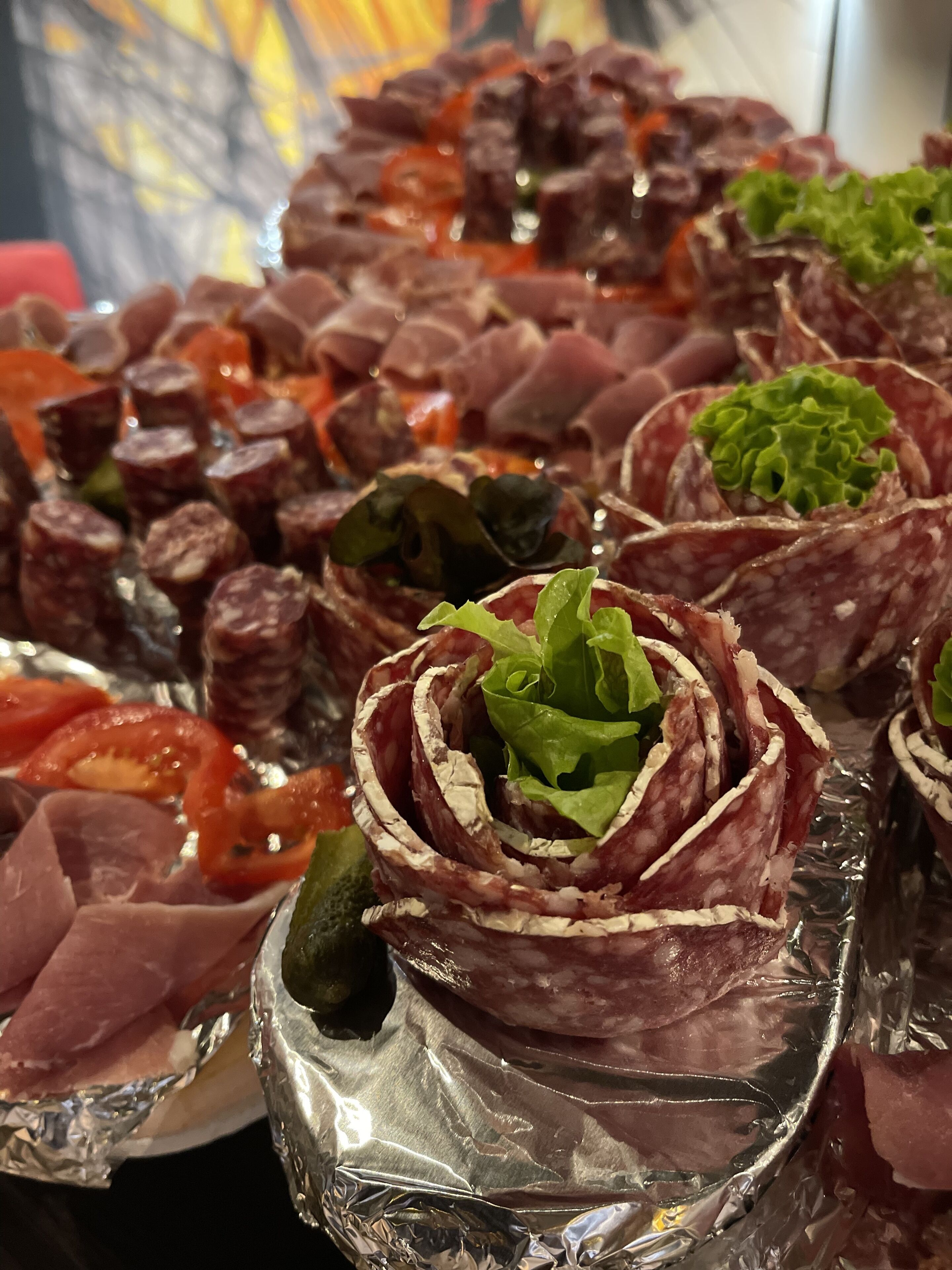 Verschiedene Speisen, darunter geschnittenes Fleisch und Gemüse, sind auf einem Tisch angerichtet.