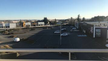 A parking lot with several cars and a few buildings in the background.
