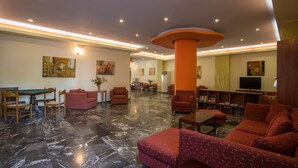 Un vestíbulo amplio con mesa de billar, asientos cómodos y televisor.