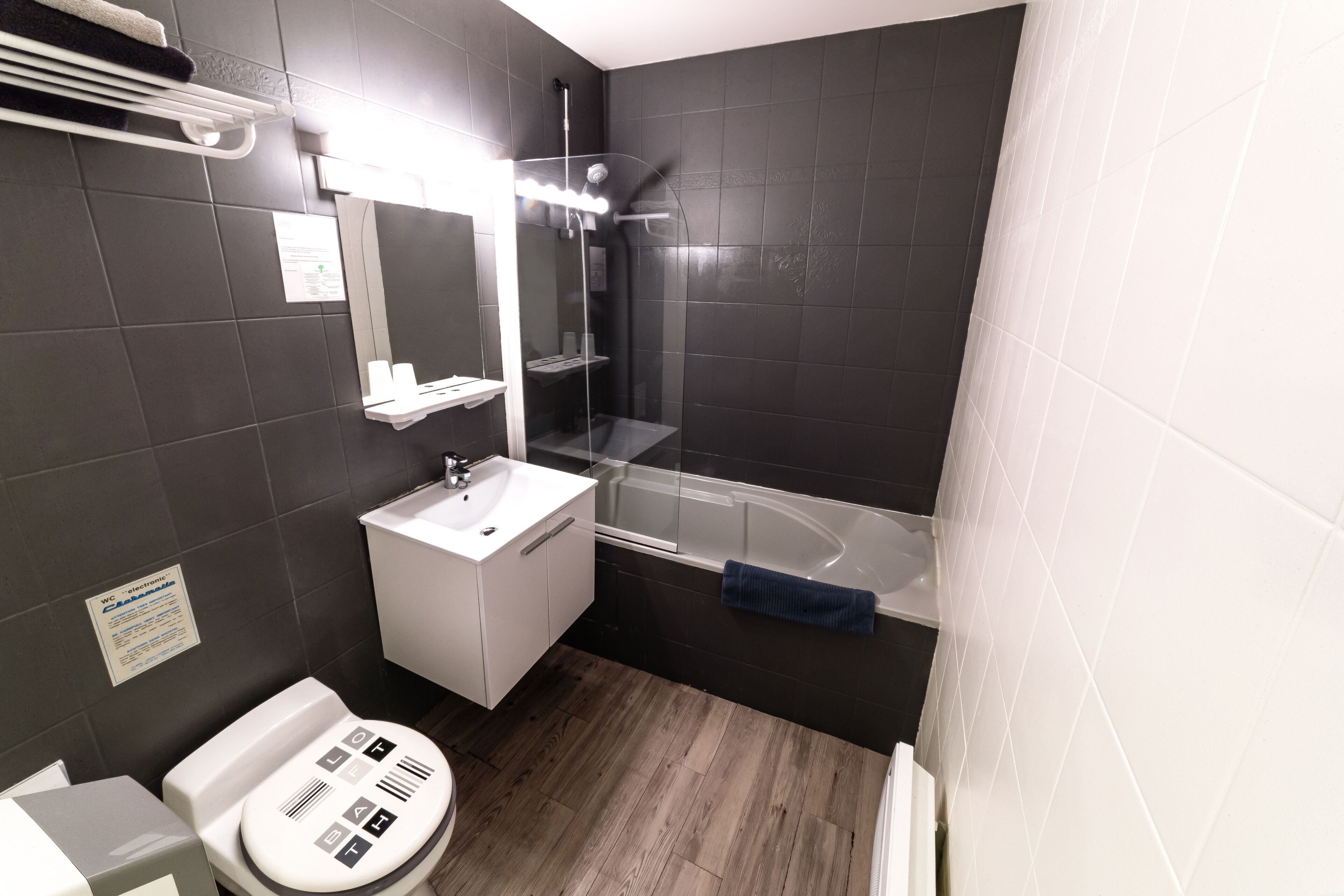 A modern bathroom with a shower, sink, and toilet.
