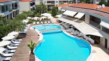 Una piscina al aire libre de temporada, sombrillas