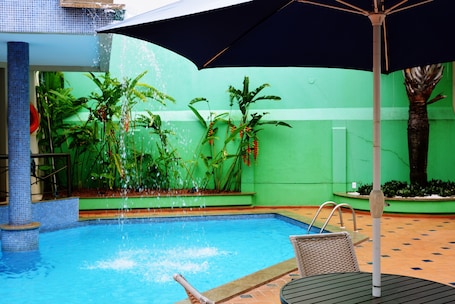 Una piscina al aire libre, sillones reclinables de piscina