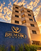 Un edificio de hotel con un letrero que dice 'BRUMADO HOTEL' y un logotipo con un árbol.