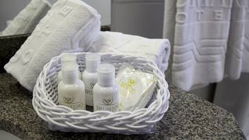 Un panier en osier contenant des flacons de gel douche Brumado et un savon, posés sur un comptoir en granit.