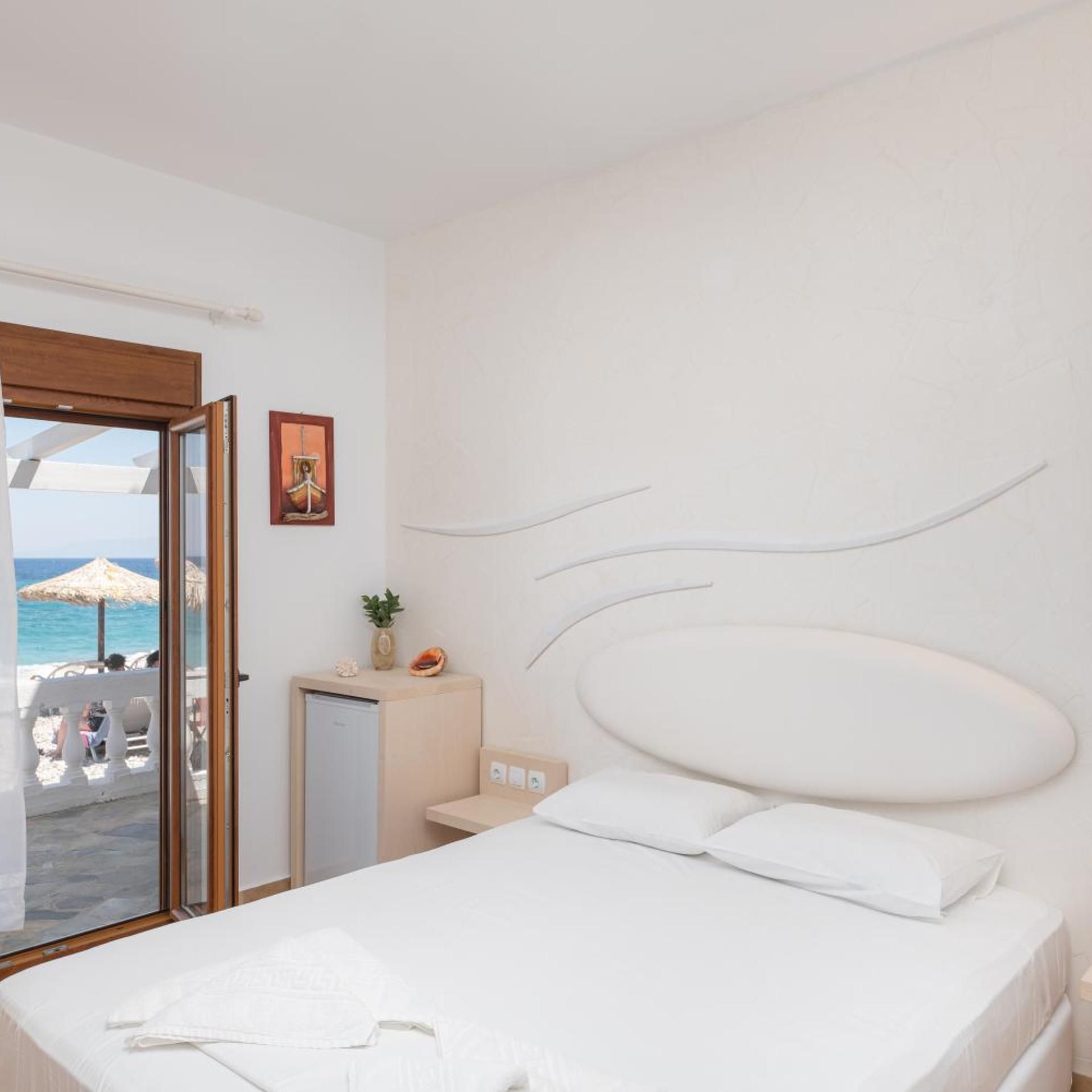 Une chambre d’hôtel avec un lit, un bureau et une vue sur la plage.
