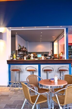 A bar area with a counter, stools, and a round table.