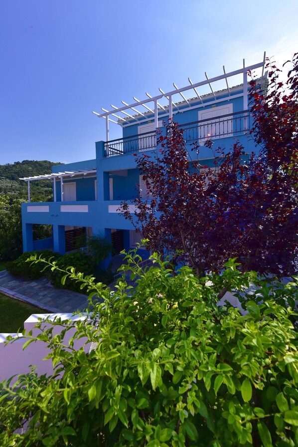 A modern two-story building with a balcony and a covered outdoor area.