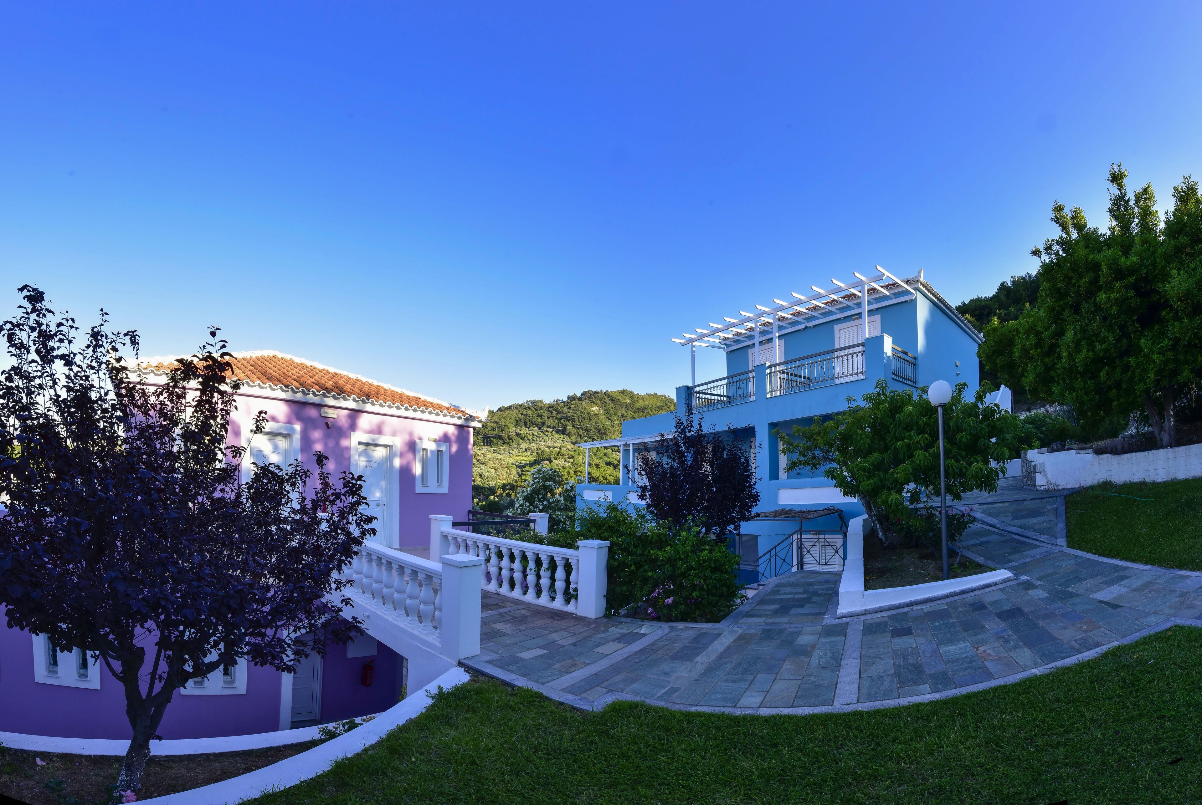 A two-story house with a balcony and a garden.