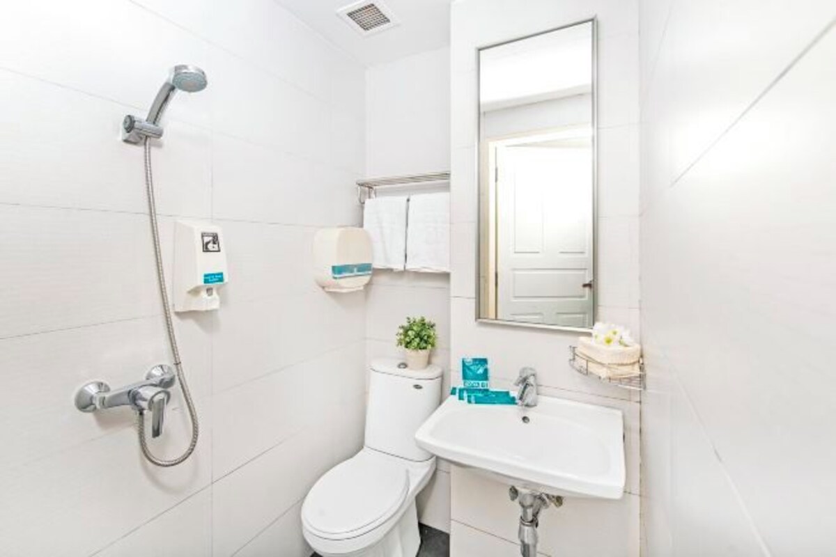 A modern bathroom with a shower, toilet, sink, and a mirror.
