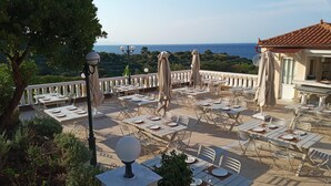 An outdoor dining area with tables and chairs, overlooking a scenic view of the sea. - Matilda Hotel by Anayia All Inclusive Resorts (Zakynthos)