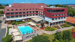 A hotel with a swimming pool, outdoor seating, and a tennis court. - Hotel Sopron (Sopron)