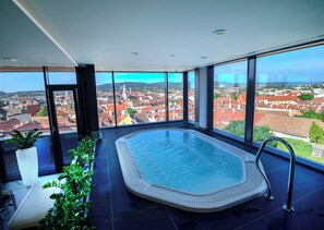 A modern indoor swimming pool with a panoramic city view. - Hotel Sopron (Sopron)