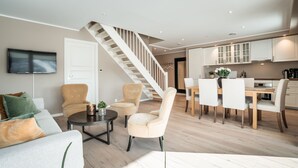 A modern living room with a staircase, a dining area, and a kitchen. - Ustedalen Hotell Geilo (Hol)