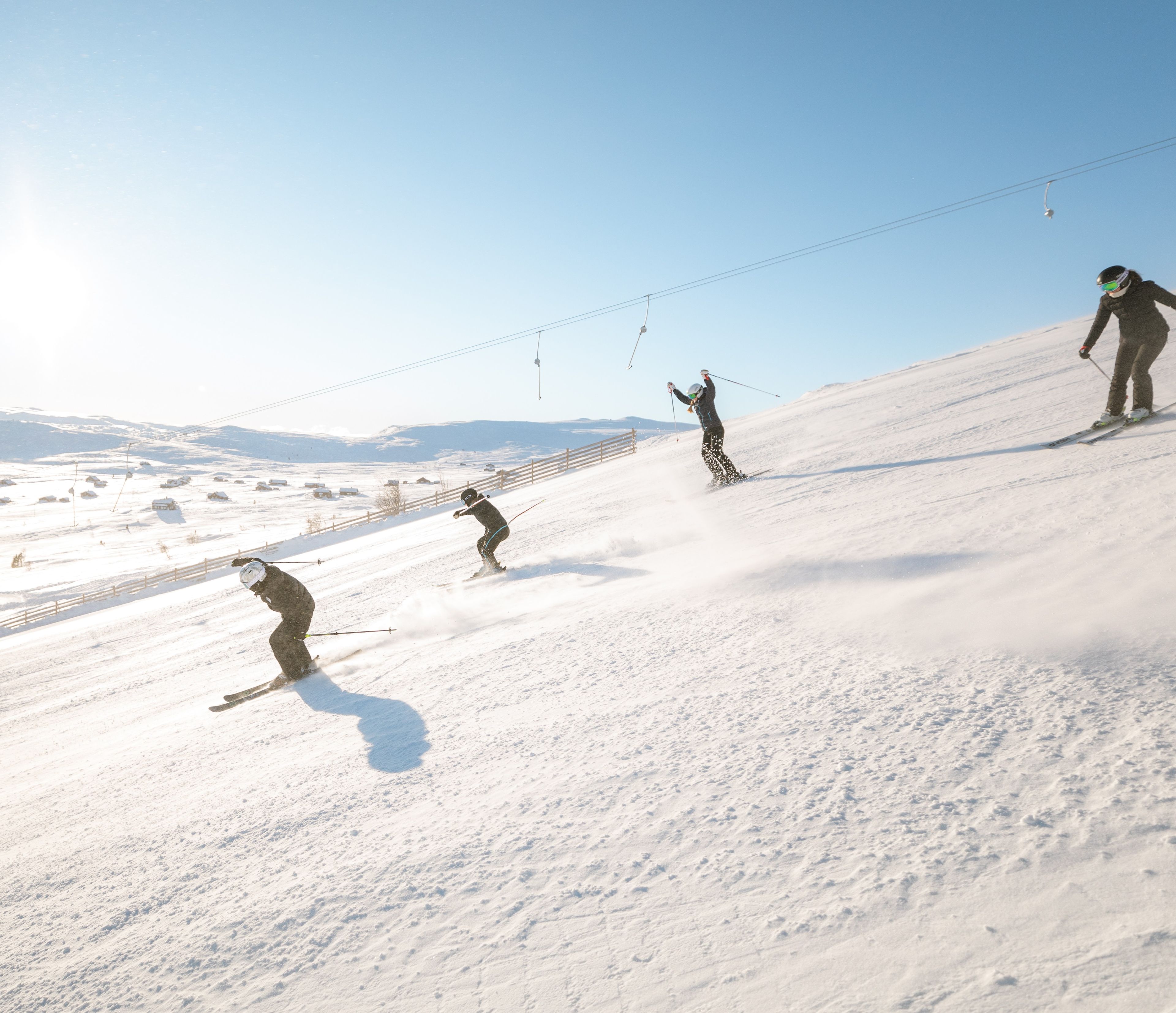 A ski slope with skiers descending.