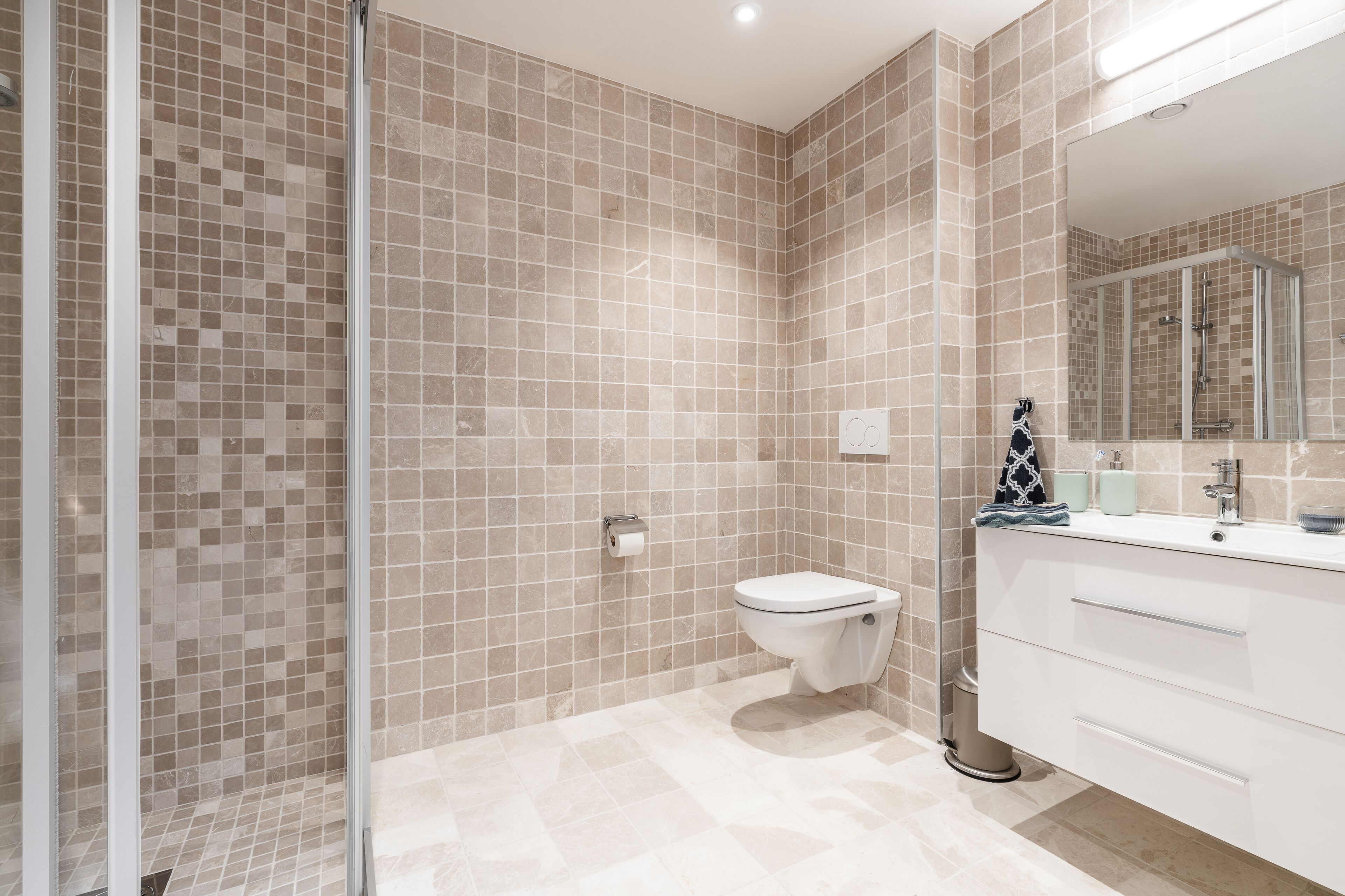 A bathroom with a shower, toilet, and vanity.