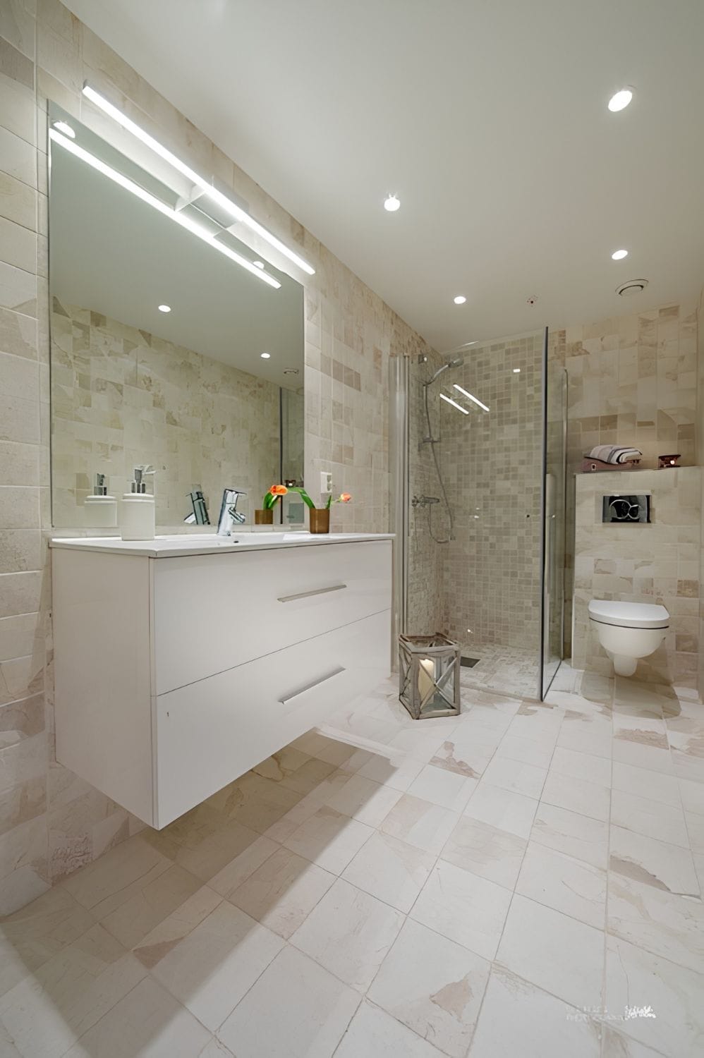 A modern bathroom with a glass-enclosed shower, a large mirror, and a white vanity.