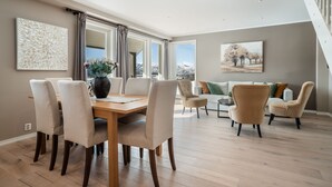 A spacious living area with a wooden dining table, beige chairs, and a sofa set. - Ustedalen Hotell Geilo (Hol)