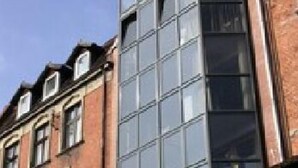 A multi-story building with a mix of traditional brick facades and modern glass windows. - Hotel Czarna Róża (Torun)