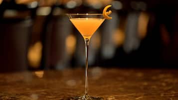 Una copa de martini con una rodaja de limón sobre una superficie de mármol.