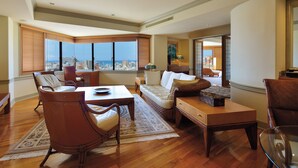 Un salón espacioso con un ventanal grande, un sofá, una mesa de comedor y una silla.