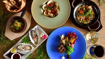 A variety of dishes including seafood, vegetables, and a blue plate with a meat dish, suggesting a diverse meal selection.
