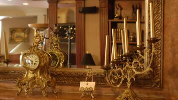 A luxurious room with ornate gold furniture, including a large mirror and a clock.
