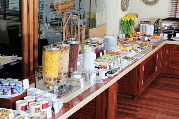 A buffet setup with various food items and containers.