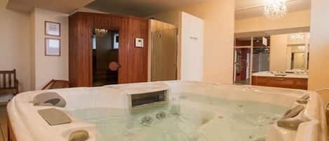 Un jacuzzi en una habitación con paredes de madera y un candelabro.