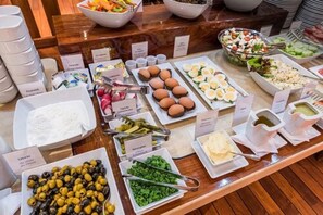 A buffet with various food items including eggs, olives, and salads.