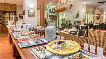 A buffet setup with various food items and utensils.