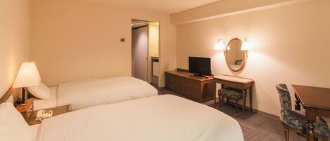 A hotel room with two beds, a desk with a chair, a television, and a mirror.