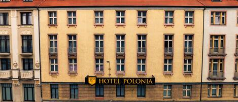 Un immeuble à plusieurs étages portant une enseigne indiquant « Hôtel Polonia ».