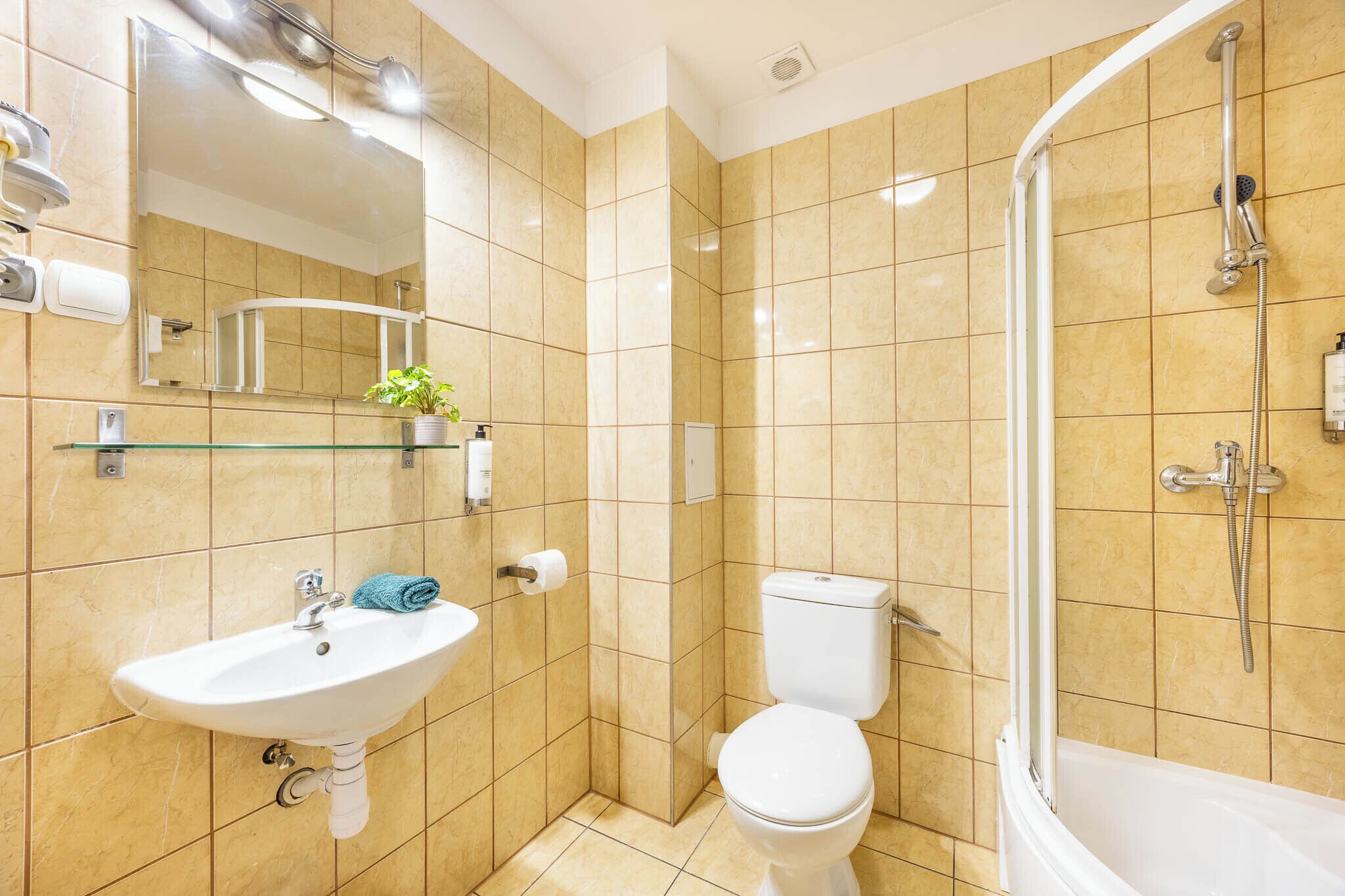 A bathroom with a sink, toilet, and shower.