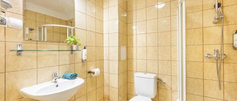 A bathroom with a sink, toilet, and shower.