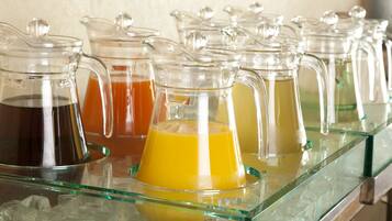 A row of glass dispensers with different colored beverages on a glass shelf.