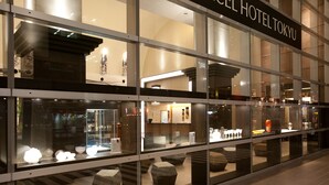 The exterior of the Hotel Tokyo with large glass windows displaying interior decor.