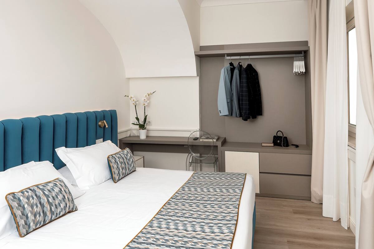 Une chambre moderne avec un grand lit, un bureau et une armoire.