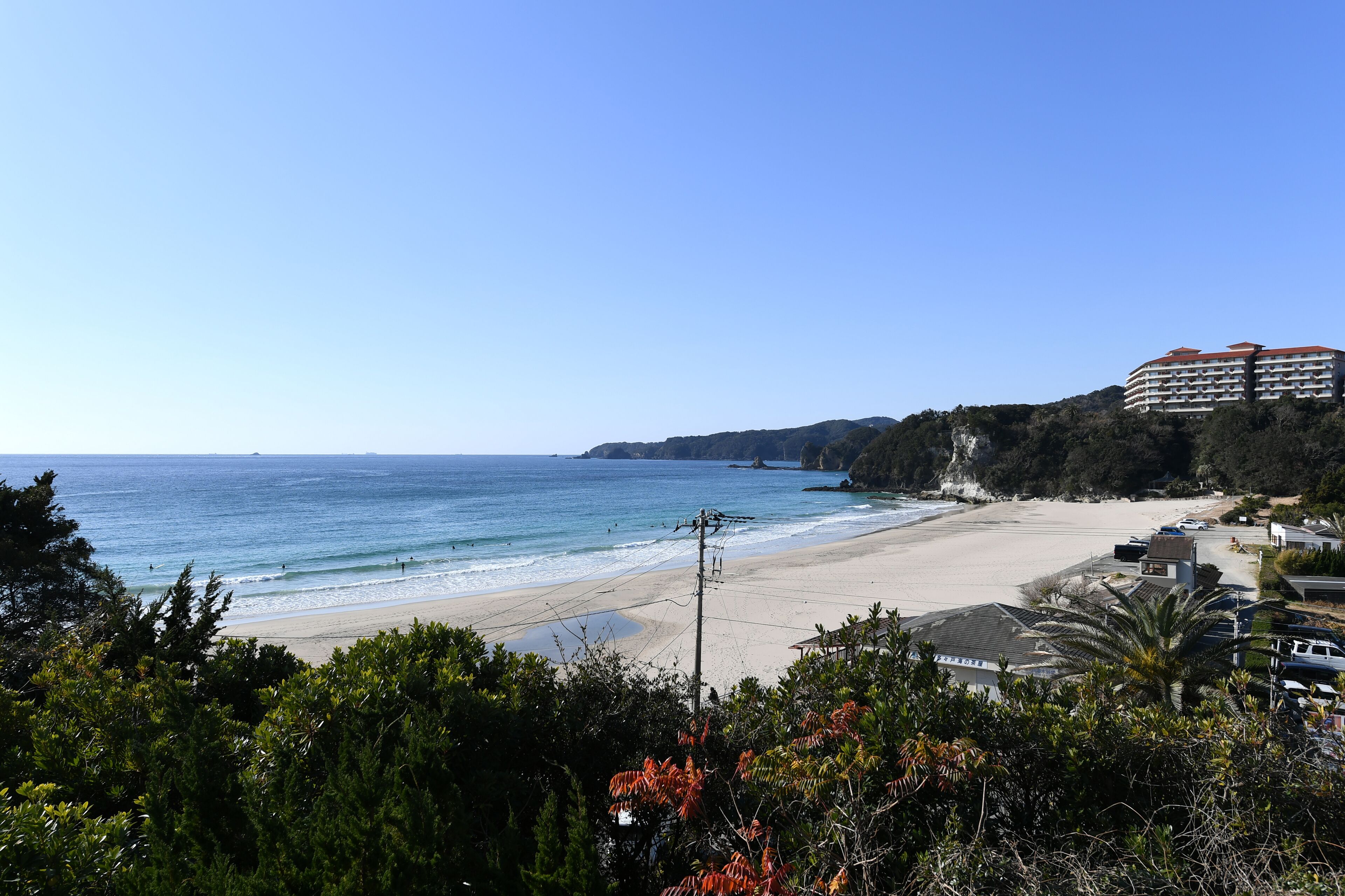 A beach with a hotel in the background.