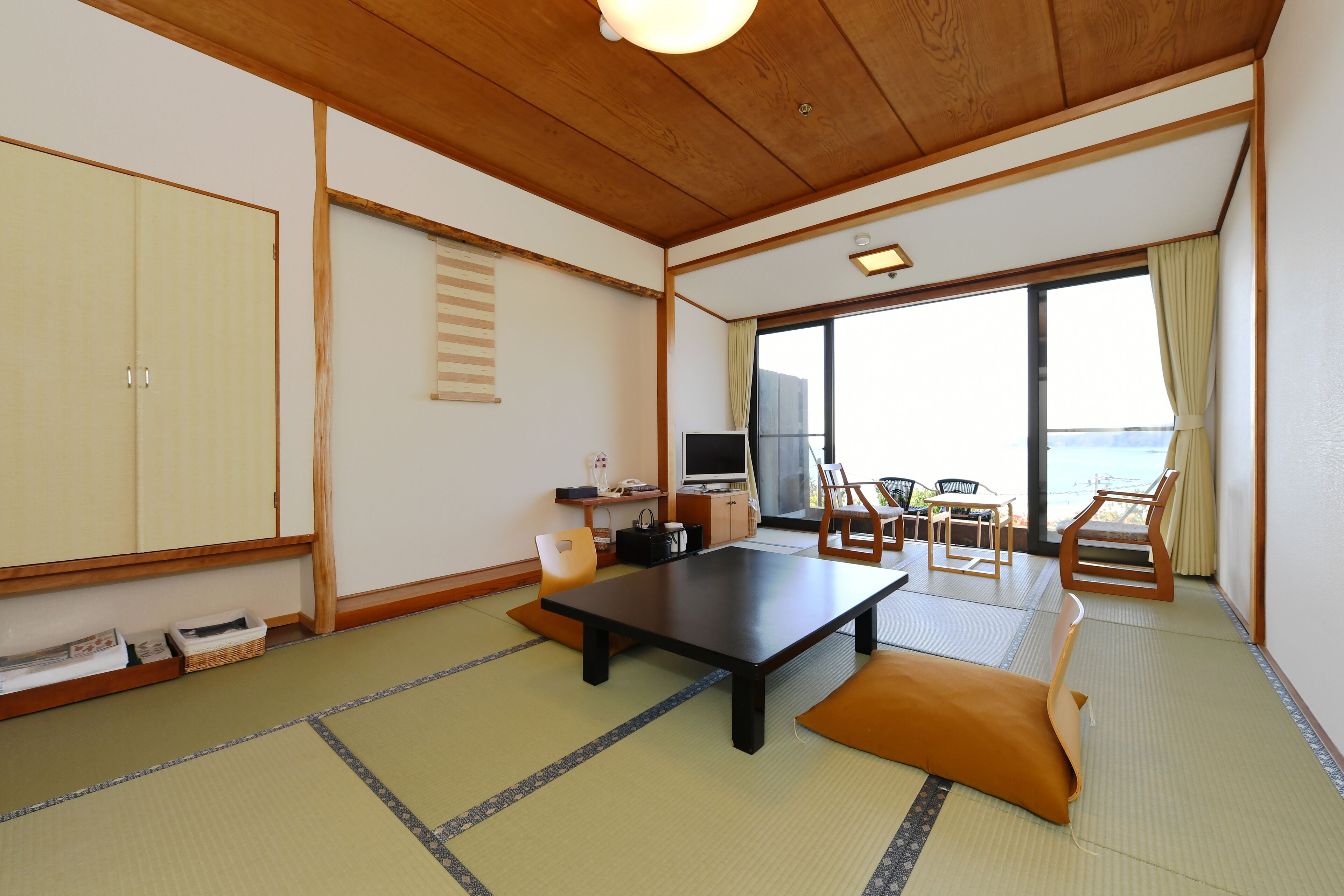 A traditional Japanese room with tatami flooring, a low table, and sliding doors.
